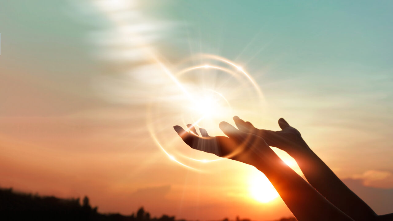 Woman hands praying for blessing from god on sunset background
